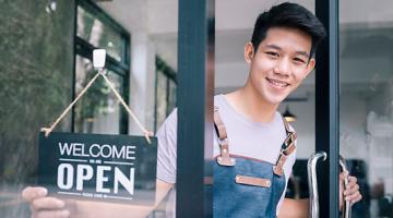 Decorate image, cafe owner at the door with a welcome open sign